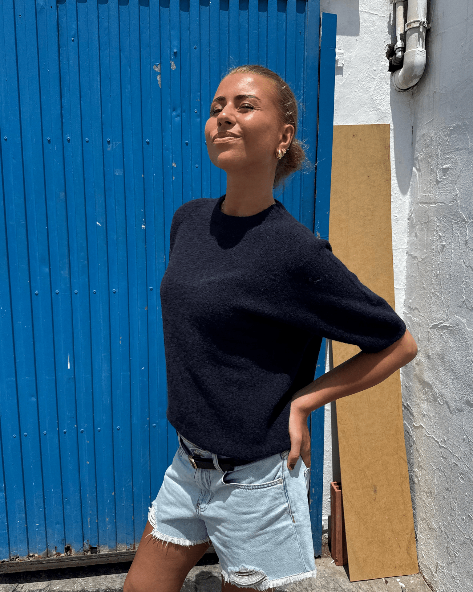 Model i navy Mira kortærmet strik med rund hals og denimshorts