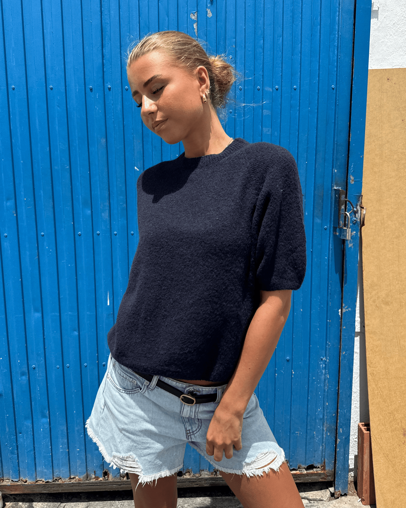 Model i navyblå Mira kortærmet strik med rund hals og lyse denimshorts