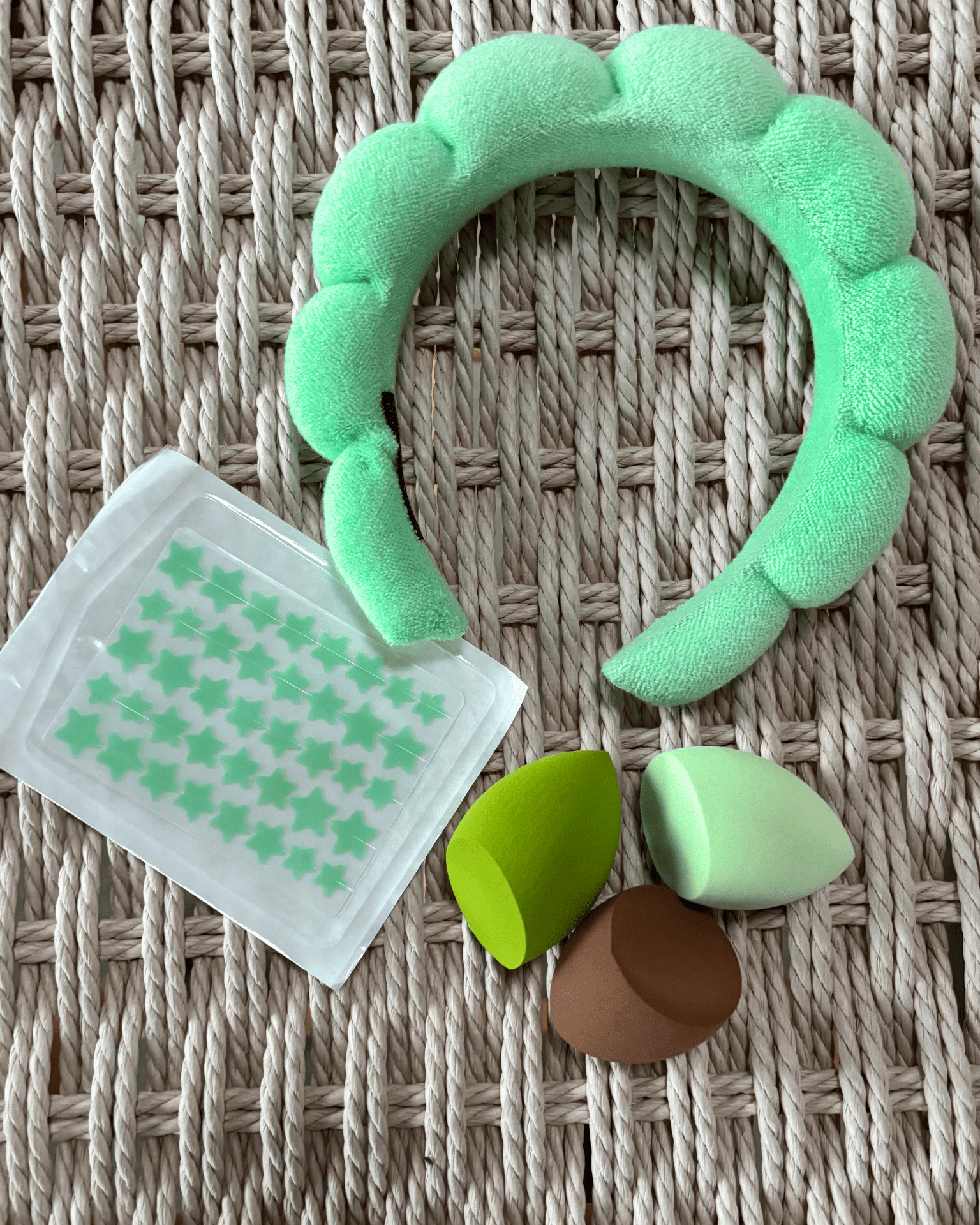 Grønt selfcare-sæt med skumpandebånd, tre beautyblenders og stjernestickers på fletbaggrund