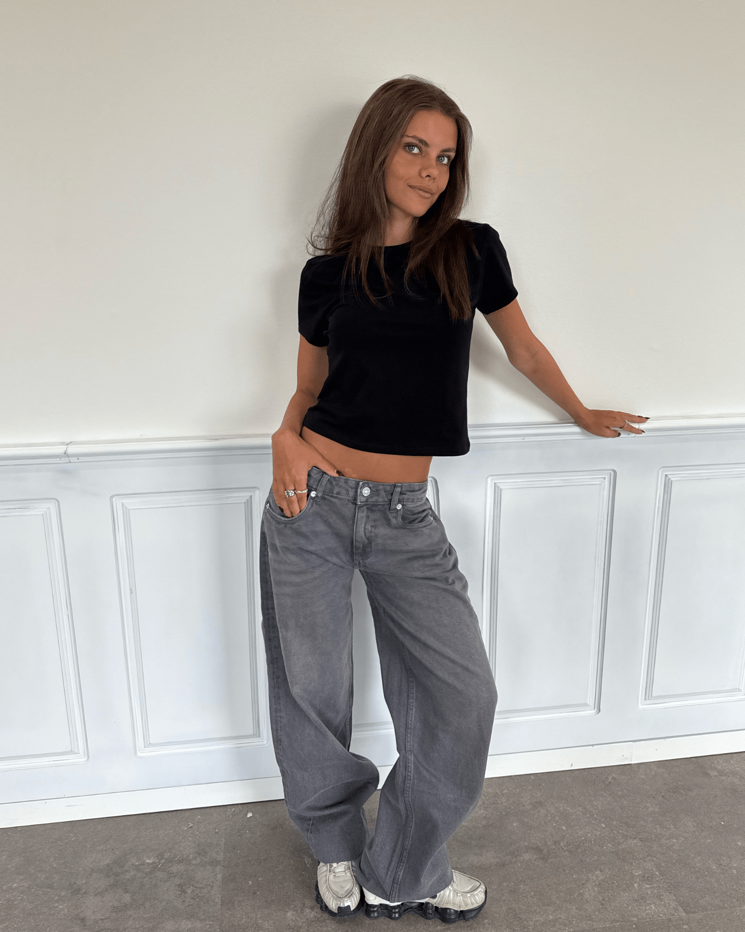 Model i mørkegrå Esther jeans med baggy fit og lav talje samt sort t-shirt