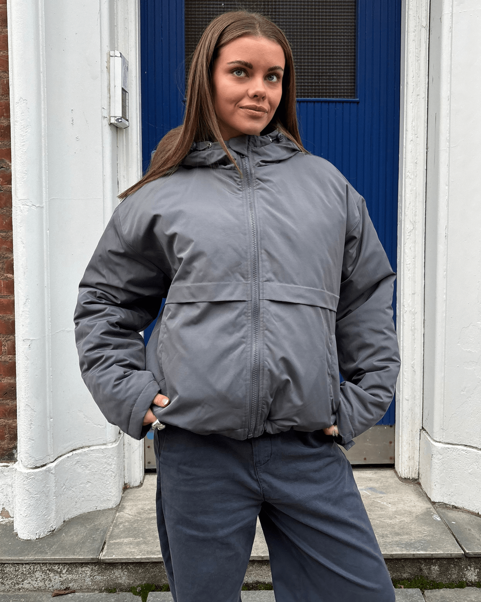 Mørkegrå Juno jakke med hætte og lynlås båret af model