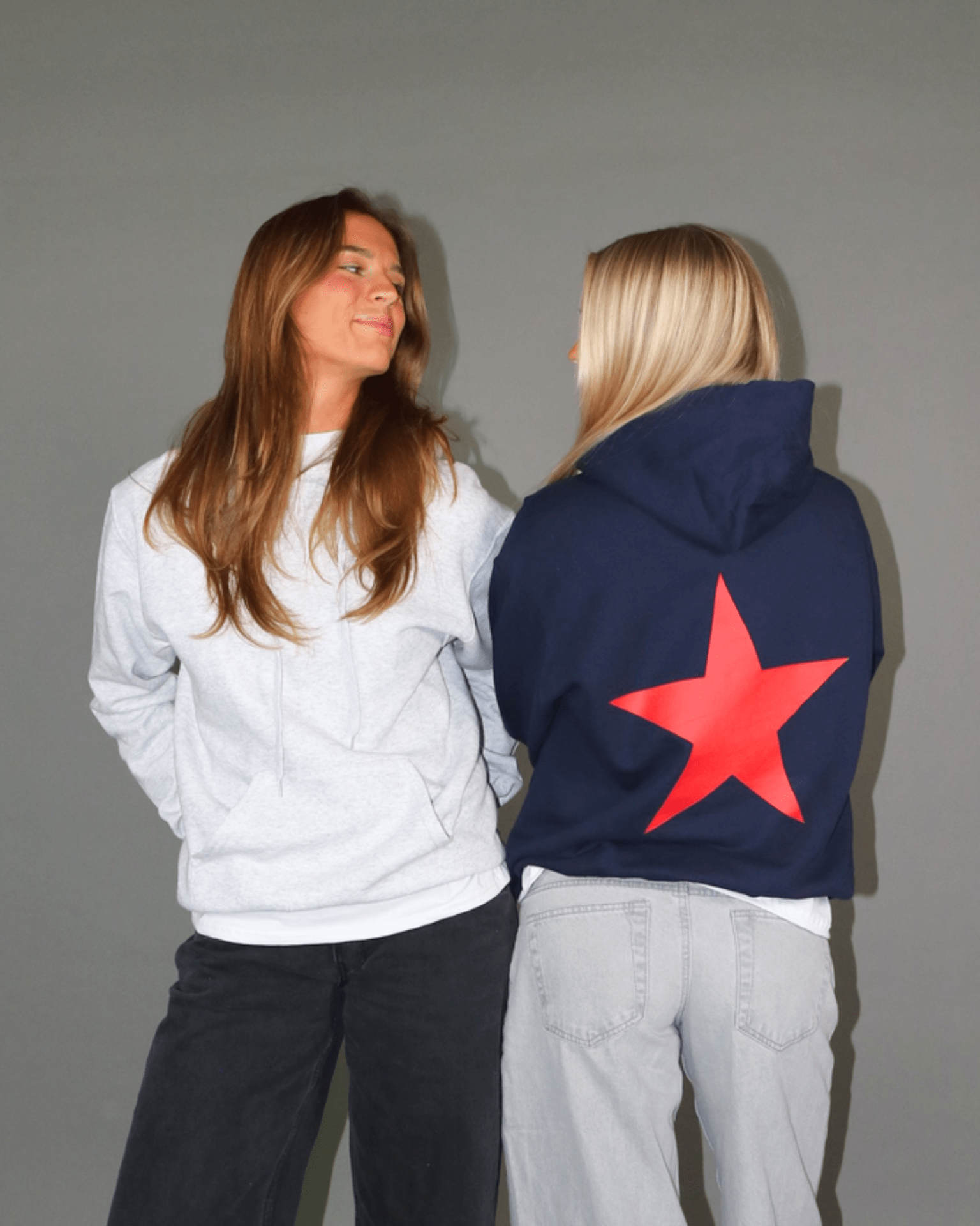 Navy hoodie med stort rødt stjerneprint på ryggen og lysegrå hoodie set bagfra og forfra