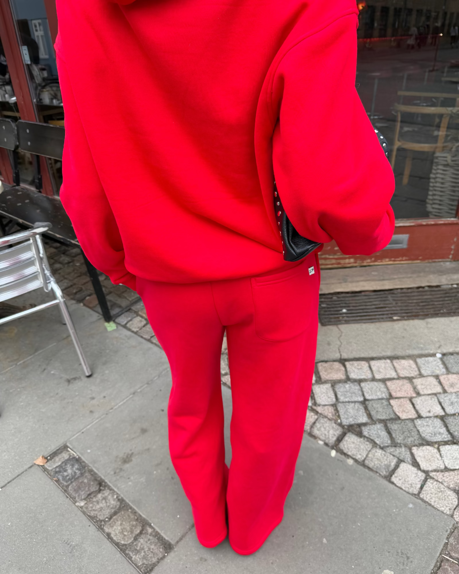Røde baggy sweatpants i blød bomuld set bagfra på gaden