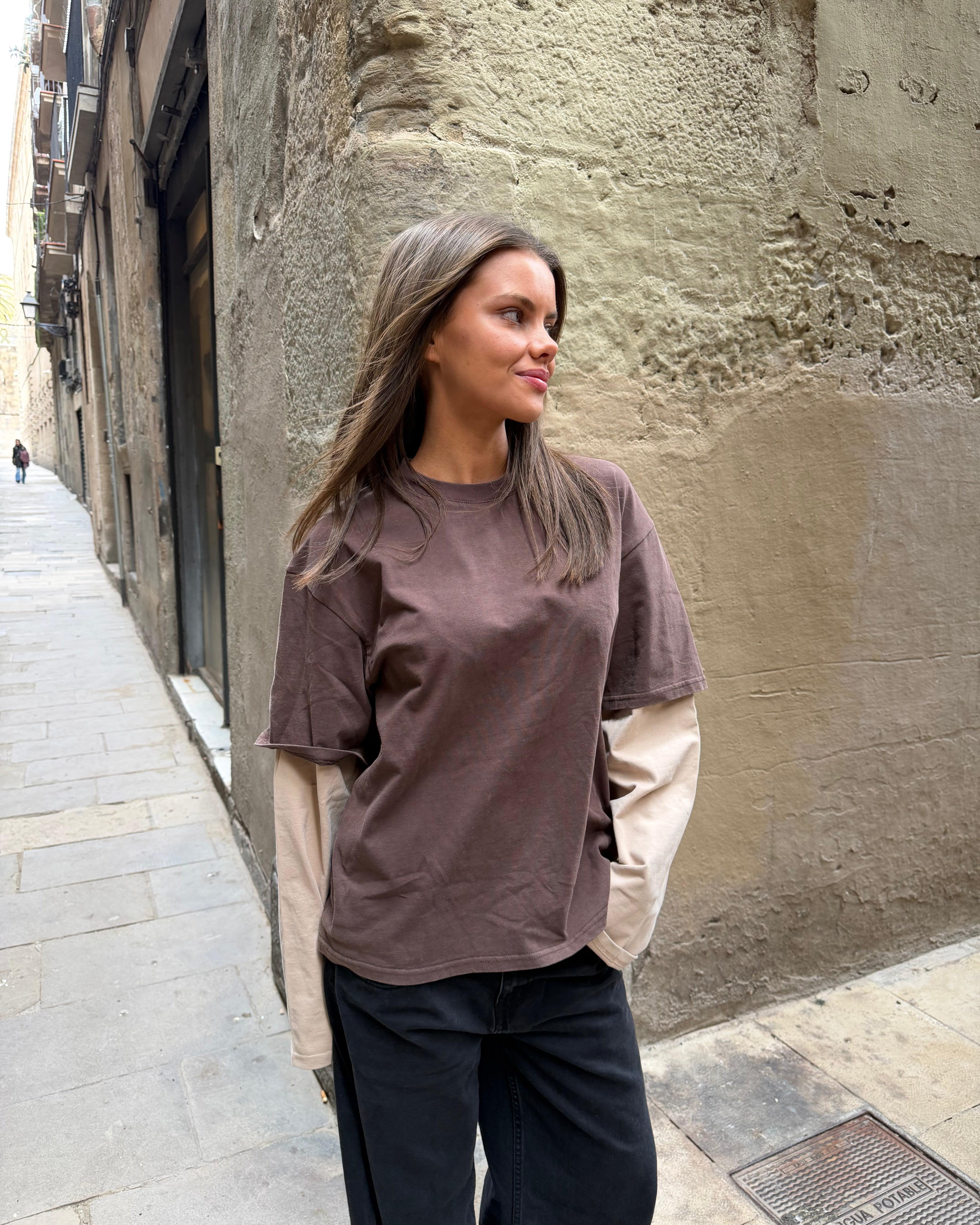 Oversize Alvia layered tee i brun og beige bomuld med lange ærmer og mørke bukser.