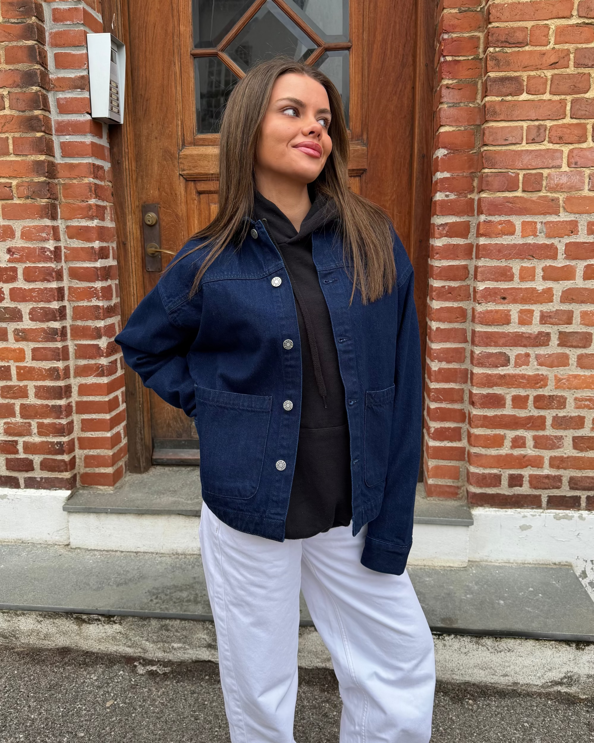 Mørkeblå Sia denimjakke med knapper og lommer, vist på model.
