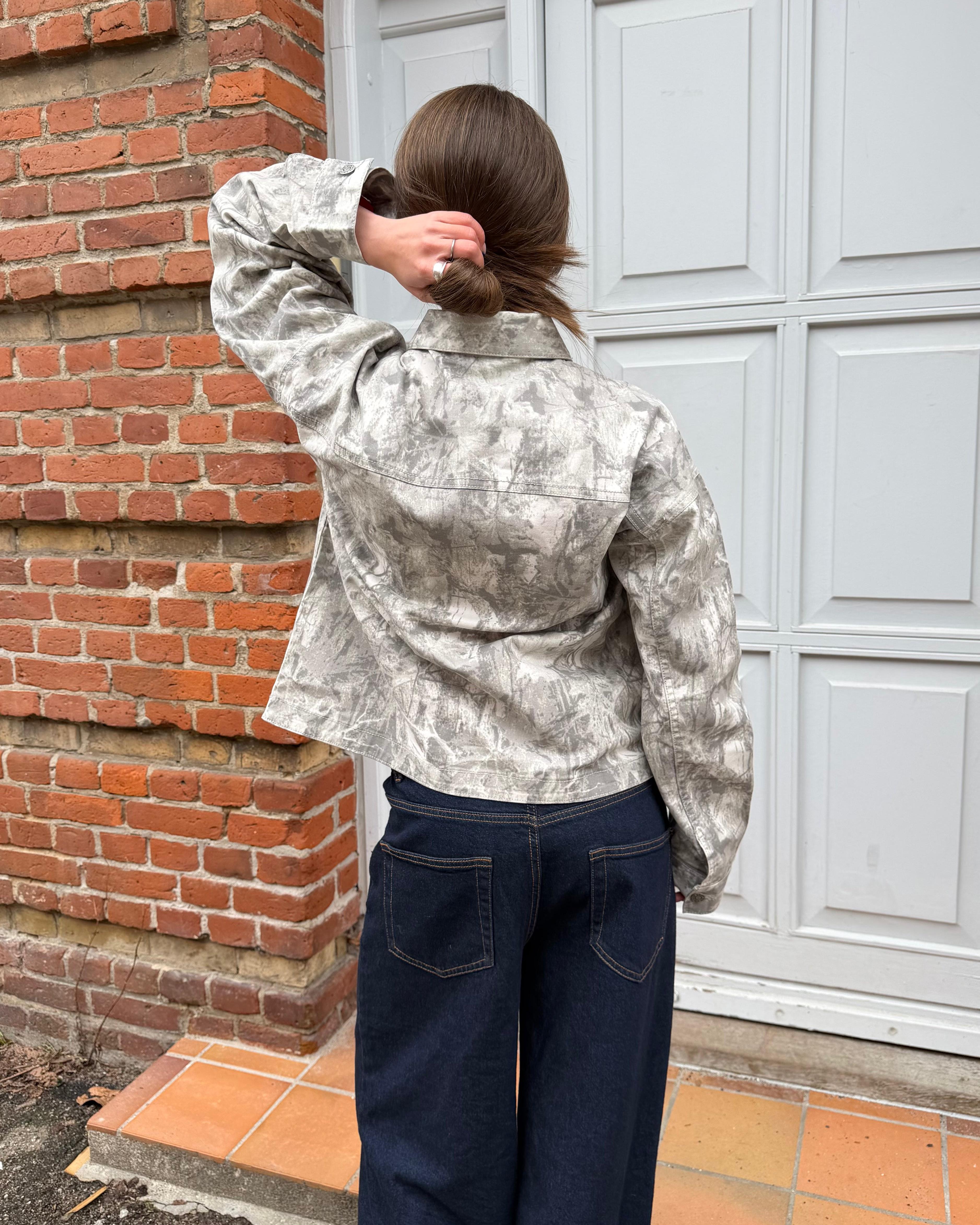 Sia denimjakke i sand forest mønster set bagfra på model i mørke jeans