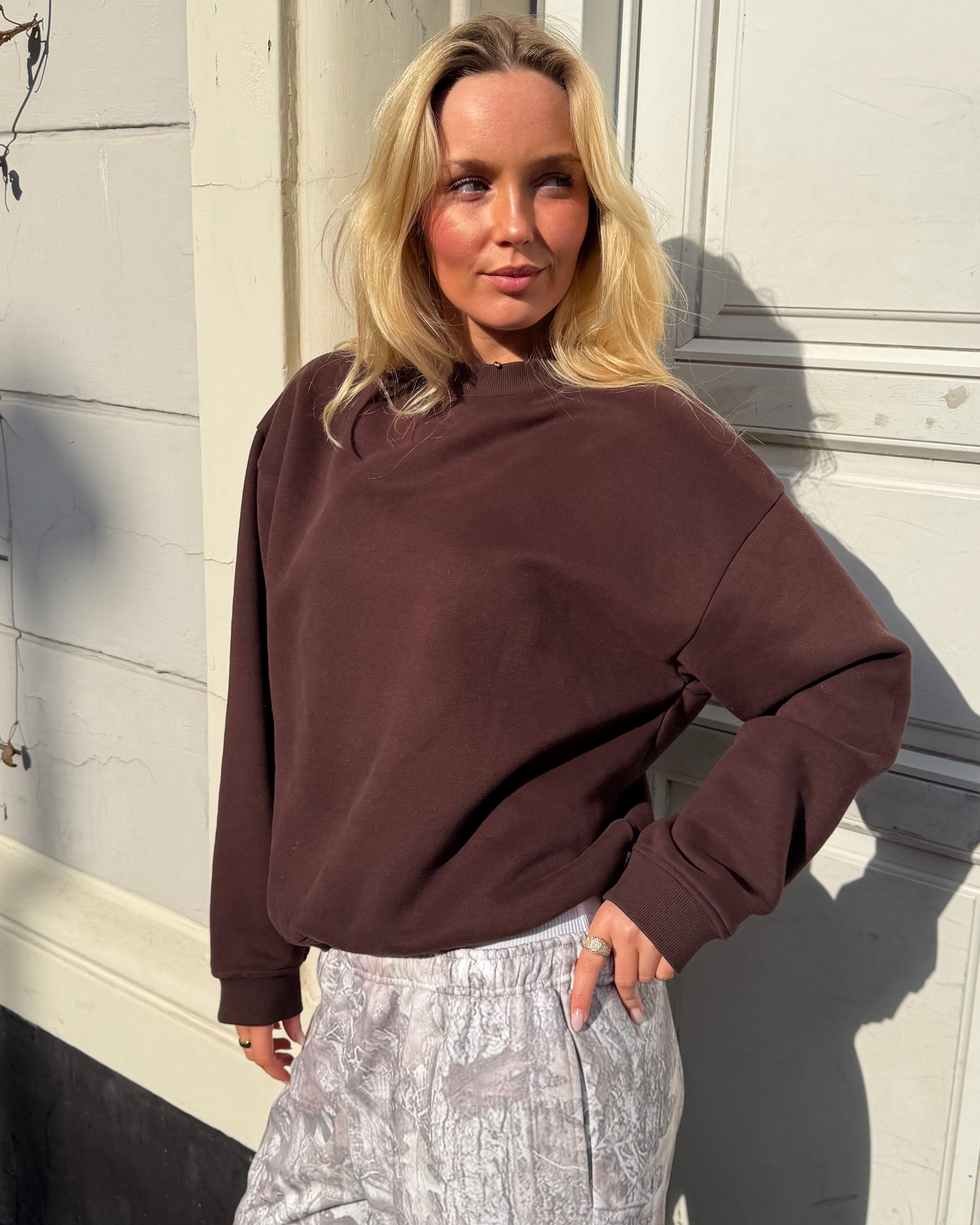 Brun oversized sweatshirt i bomuld på model, der kigger til siden