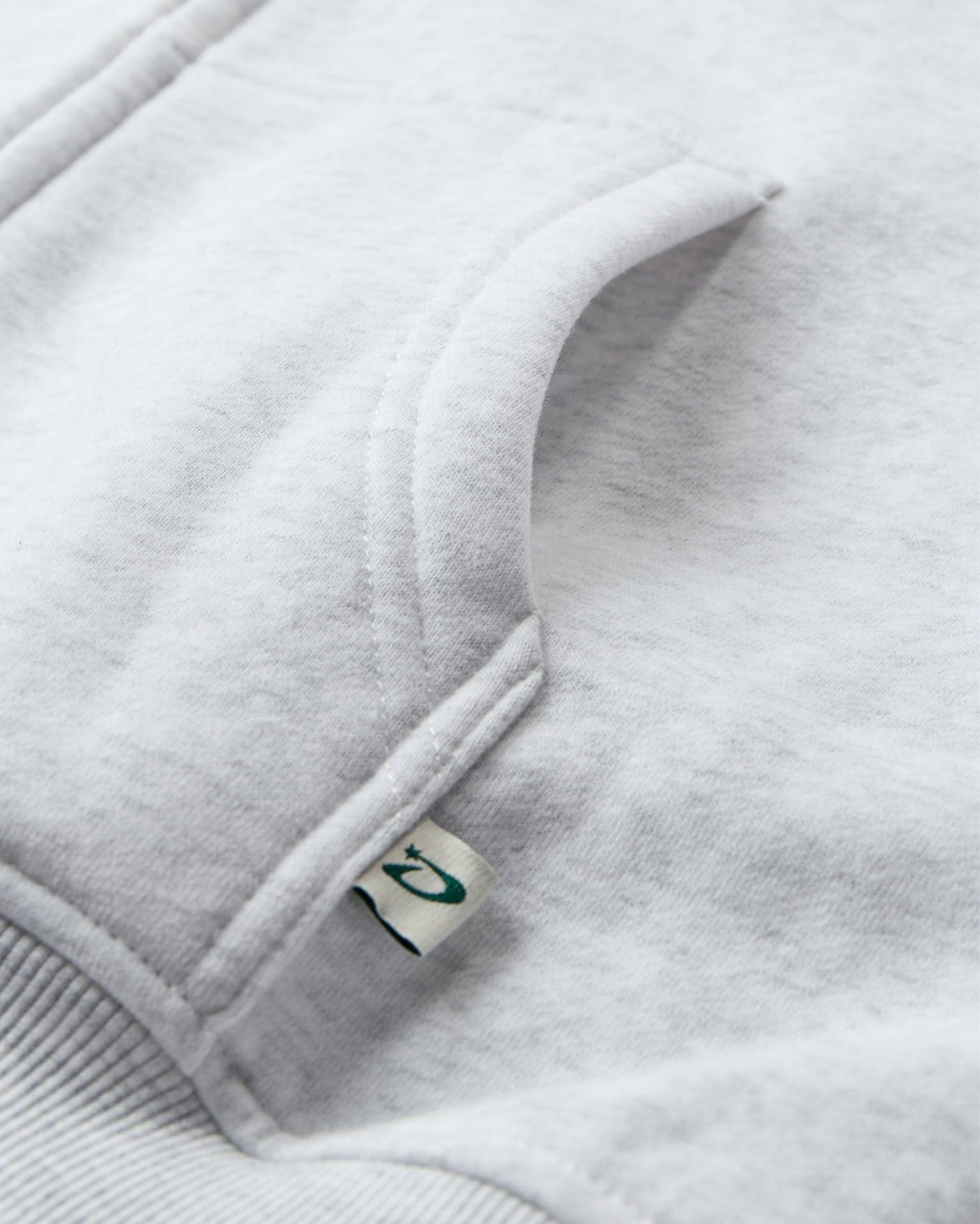 Nærbillede af lysegrå oversized zip hoodie i blød bomuld med lomme og lille mærke