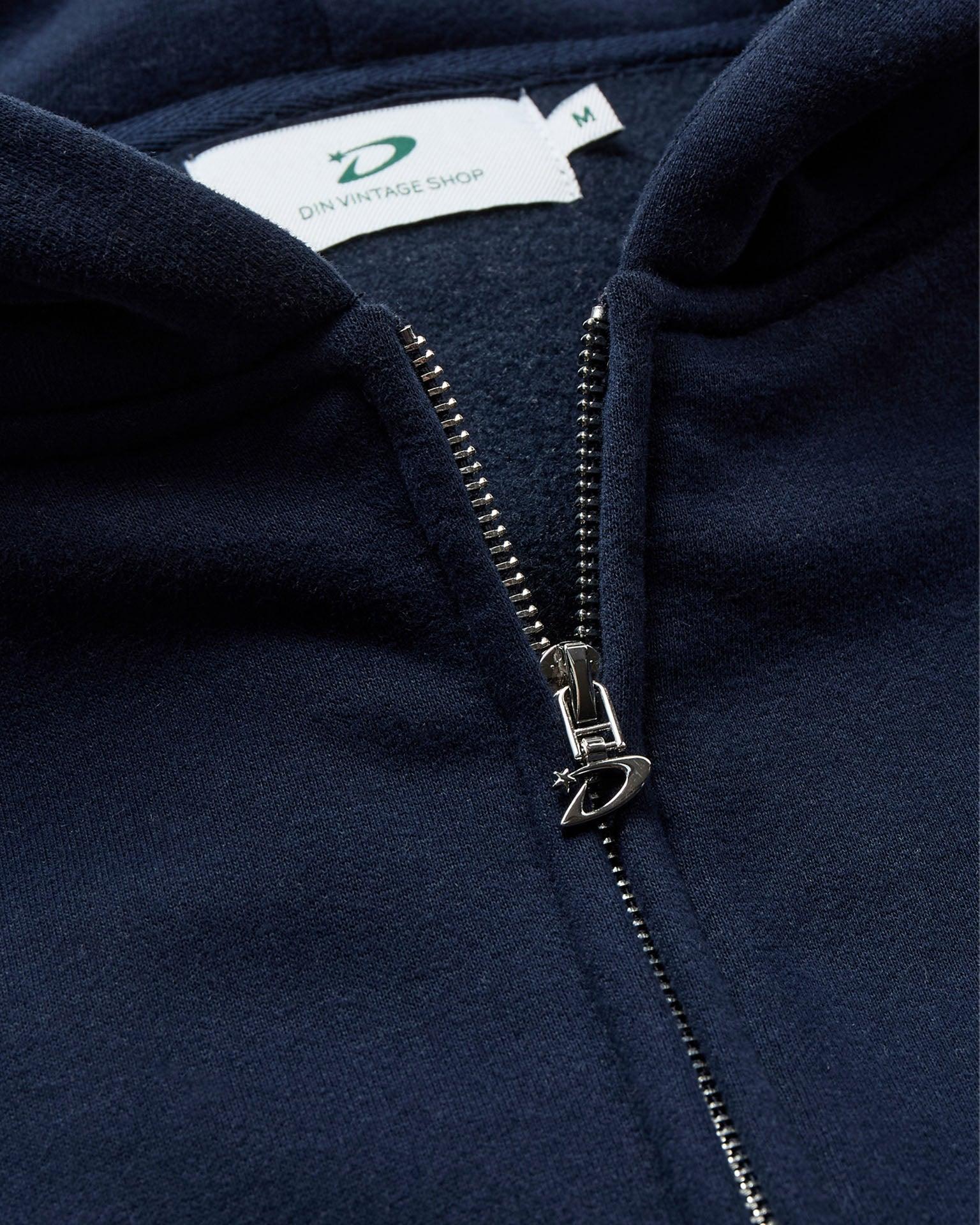 Nærbillede af navyblå zip hoodie i bomuld med metallynlås og Din Vintage Shop mærke