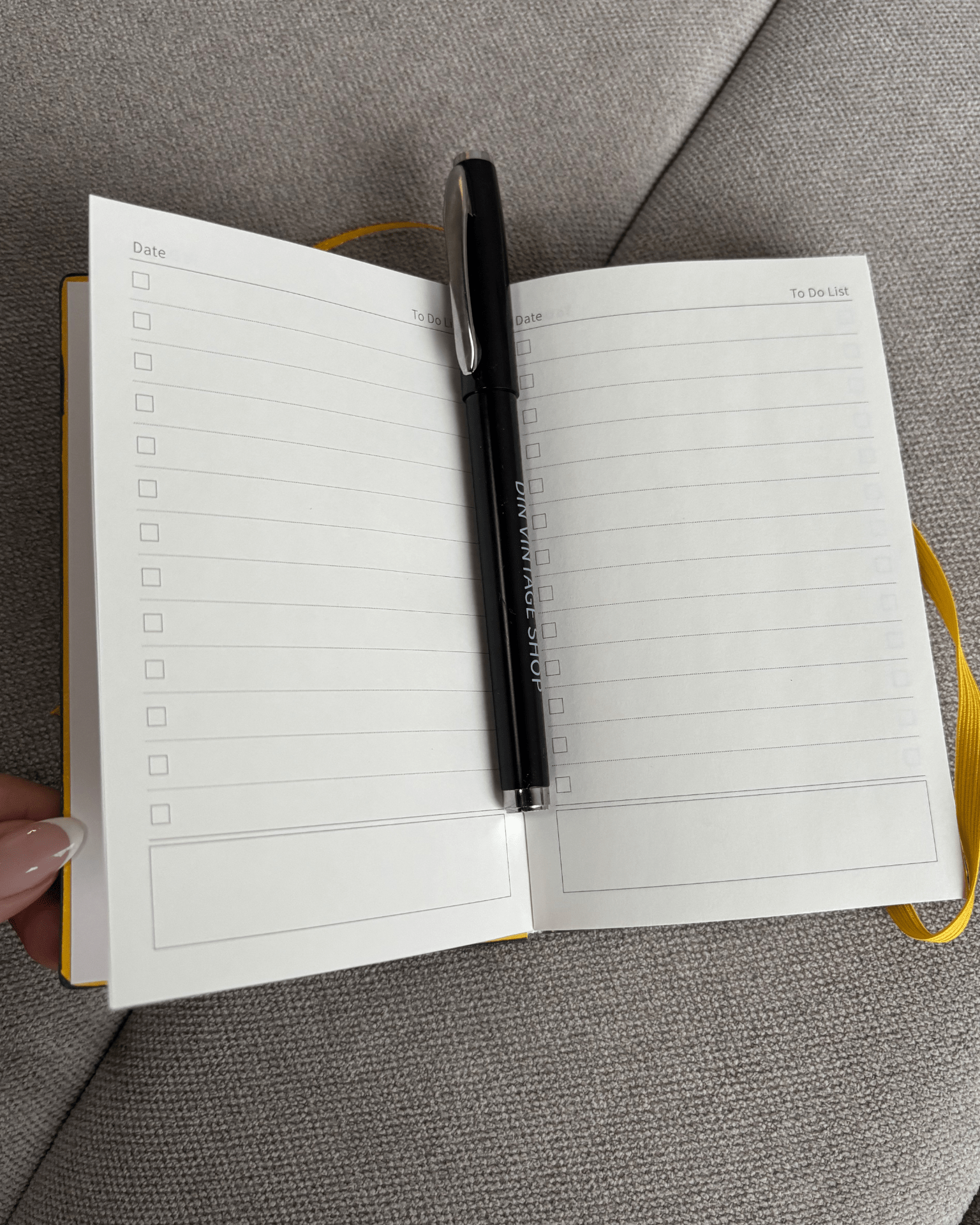 Åben grøn Din Vintage Shop planner med to-do lister og en sort kuglepen