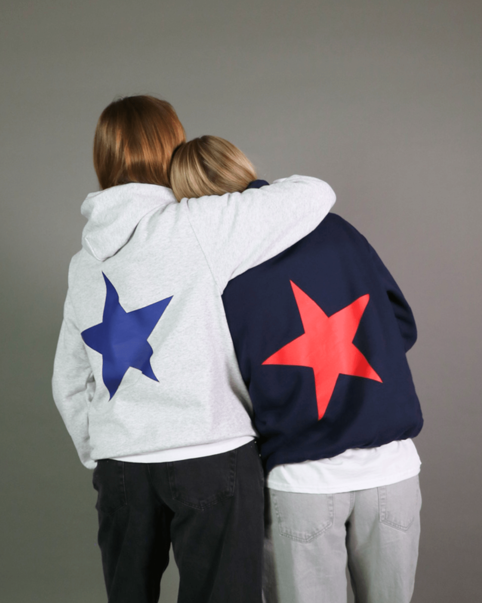 Navy hoodie med stort rødt stjerneprint på ryggen, vist ved siden af en grå model