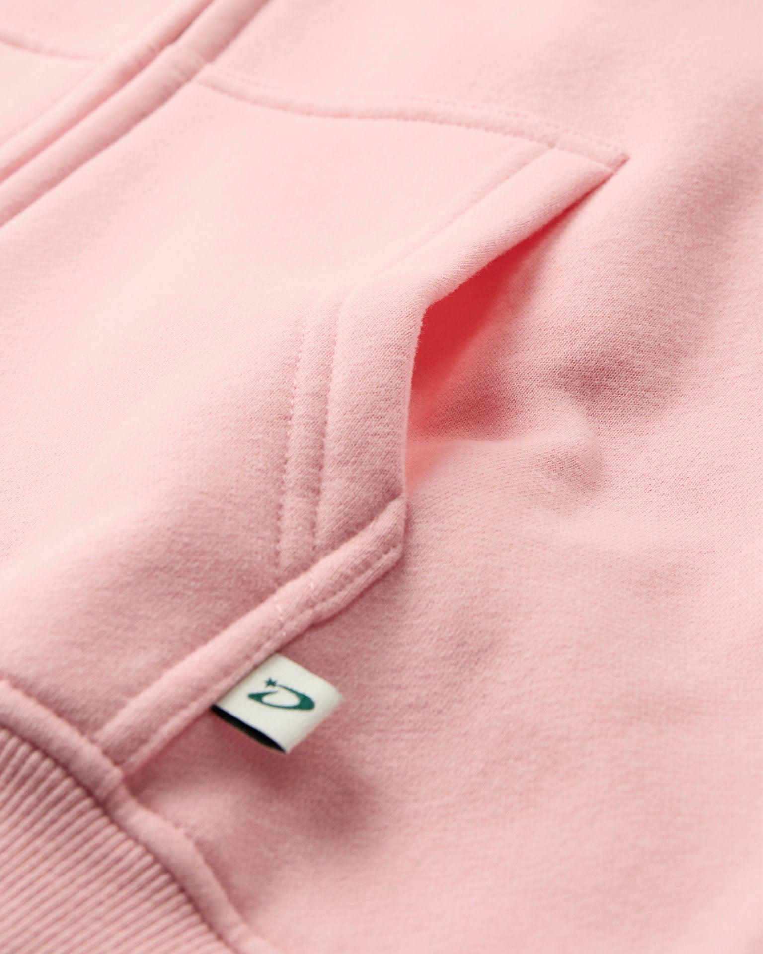Nærbillede af lyserød oversized zip hoodie i blød bomuld med lomme og lille mærke